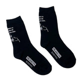 A set of three crew-length socks in white, beige, and black, celebrating Snoopy's 75th anniversary. Features clean, line-art illustrations of Snoopy and Woodstock in their most recognizable poses.