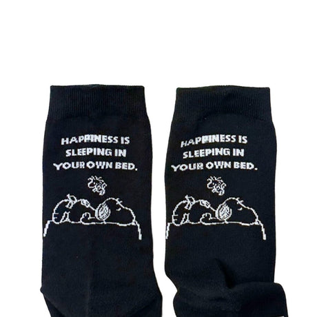 A set of three crew-length socks in white, beige, and black, celebrating Snoopy's 75th anniversary. Features clean, line-art illustrations of Snoopy and Woodstock in their most recognizable poses.