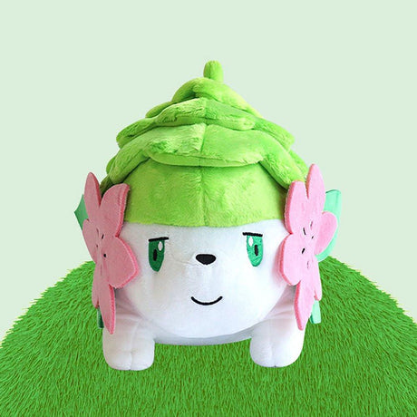 Official Pokémon Shaymin Land Forme 10-inch plush, an ideal cute gift for kids who love nature and animals. Featuring soft green fur and pink flowers, this safe and huggable stuffed toy is perfect for children's birthday presents and nursery decor. A popular Pokémon plushie for young fans.