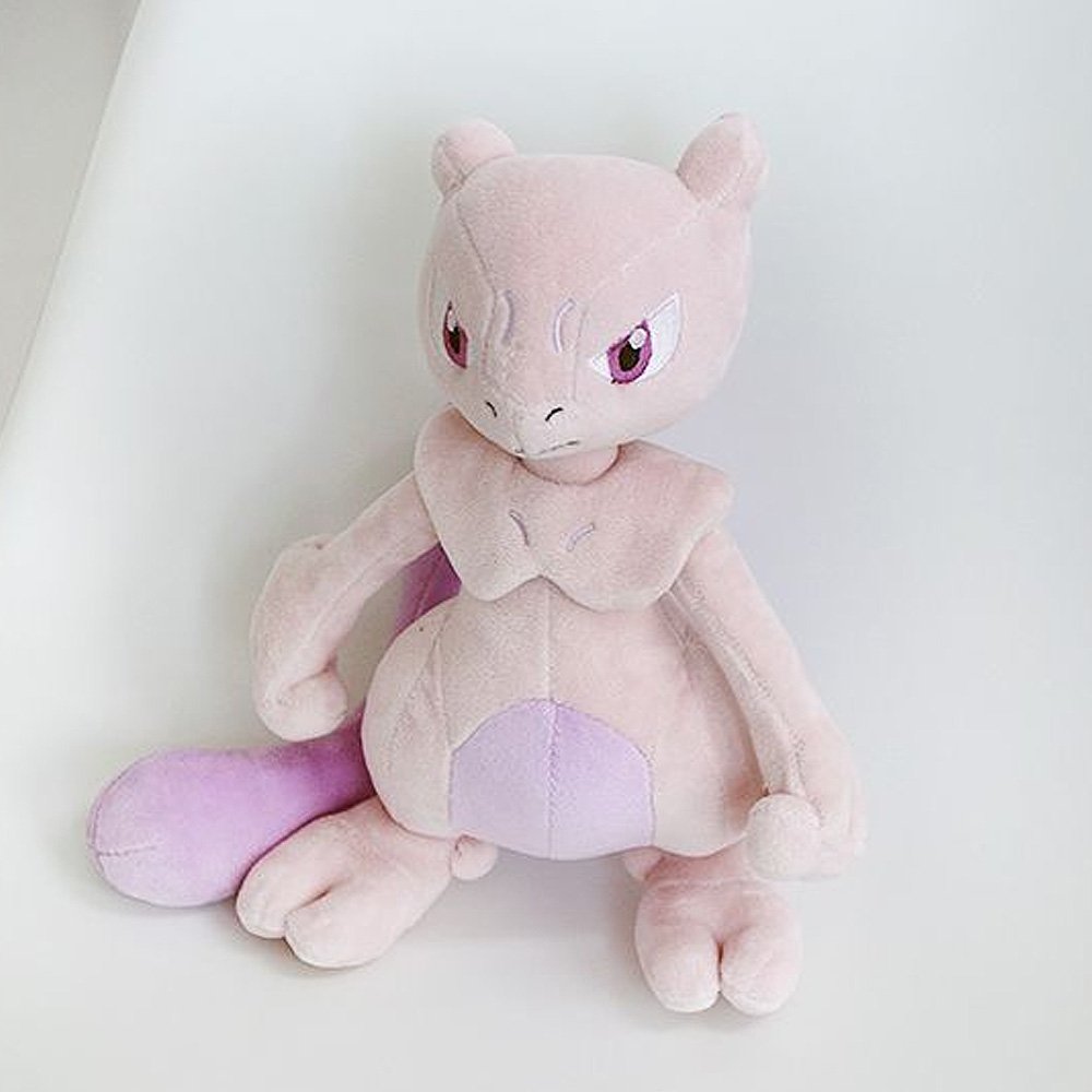 A soft plush toy of the Pokémon Mewtwo, featuring its light purple body, darker purple belly, and long tail, standing upright on a white background