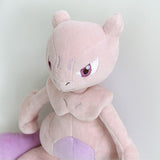 A soft plush toy of the Pokémon Mewtwo, featuring its light purple body, darker purple belly, and long tail, standing upright on a white background