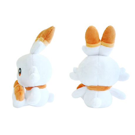 An officially licensed Pokemon plush toy of the Fire-type starter Scorbunny, featuring long ears with orange tips, large embroidered eyes, a yellow bandage-like marking on its nose, and bright orange feet.