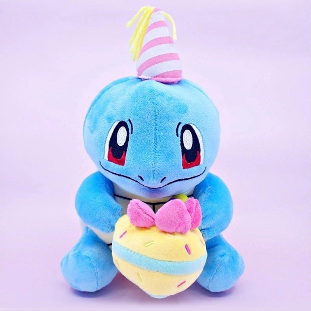 Officially licensed Pokemon plush Squirtle wears a charming party hat topped with a bright yellow tassel, and holing a cake for celebrating a special day