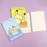 Three pastel-colored Pokemon Pokepeace spiral notebooks showcase adorable illustrations of Pikachu, Scorbunny, and other characters alongside cakes and sweets on green, yellow, and blue covers.
