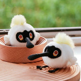 A round, fluffy Black-faced Spoonbill bird plush keychain with a distinctive long beak, a playful tuft of yellow fur, and small black feet