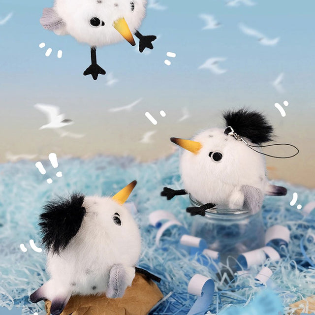 A round, fluffy white Chinese Crested Tern bird plush keychain with a spiky black crest, speckled body details, and a yellow-tipped beak