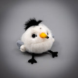 A round, fluffy white Chinese Crested Tern bird plush keychain with a spiky black crest, speckled body details, and a yellow-tipped beak