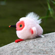 A round, light pink Crested Ibis bird plush keychain with a bright red face, red feet, and a wispy white crest