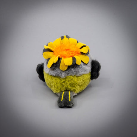 A round, fluffy Goldcrest bird plush keychain with a grey head, cream-colored body, and dark grey wings, wearing a bright yellow head crest, featuring small black eyes and long brown legs