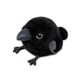 A round, fluffy black crow plush keychain features a large shiny dark blue beak, small embroidered eyes, tiny grey wing patches, and small black feet sticking out from its spherical body.