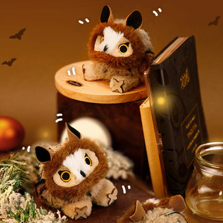 A round, fluffy brown Long-eared Owl bird plush keychain with a cream-colored face and golden eyes