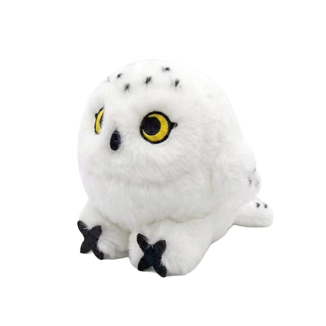 An adorable, round snowy owl plush keychain with fluffy white fur and black speckles on its head and tail. The plush features large, bright yellow embroidered eyes, a tiny black beak, and prominent black talons peeking out from its spherical body.