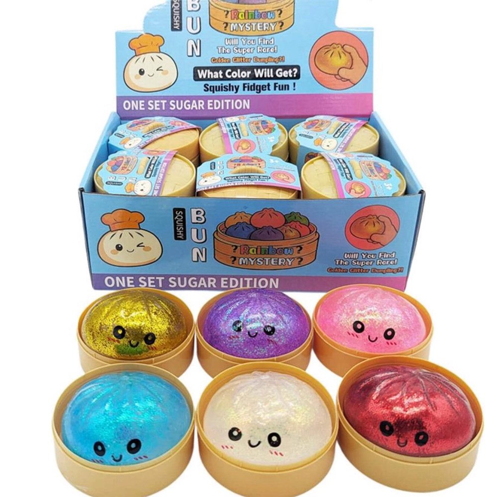 Six colorful, glittery Rainbow Mystery Squishy dumpling toys with cute cartoon faces sit inside mini plastic bun steamer baskets