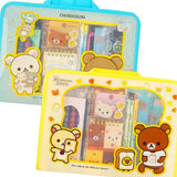 Two officially licensed Rilakkuma and Chairoikoguma stationery sets in clear plastic carry cases with handles. Both cases are packed with notebooks, pencils, and other stationery items.
