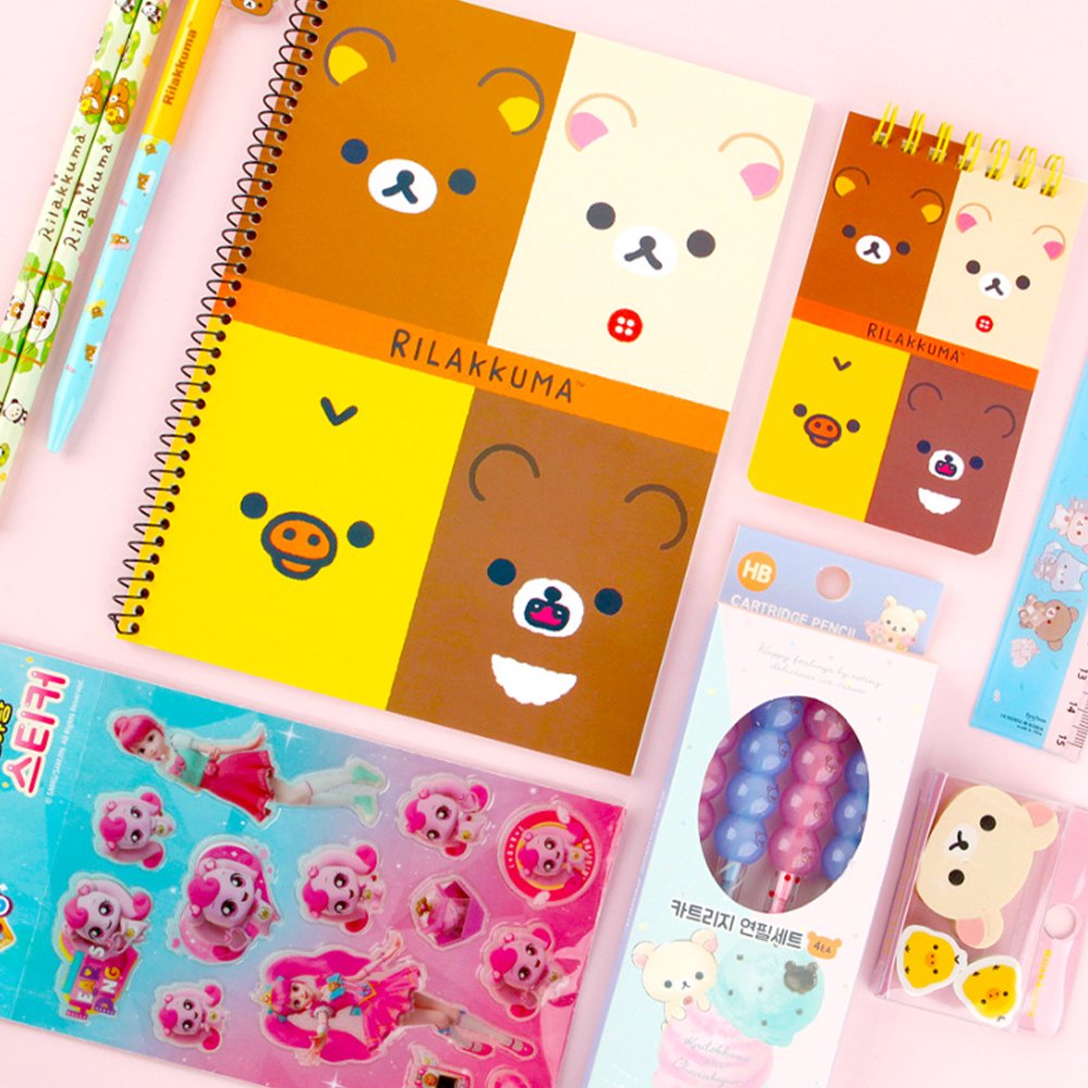 Two officially licensed Rilakkuma and Chairoikoguma stationery sets in clear plastic carry cases with handles. Both cases are packed with notebooks, pencils, and other stationery items.