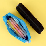 Three officially licensed Sanrio fabric pencil cases featuring stitched faux-leather character patches. An open blue pouch reveals highlighters and pens stored inside the main zippered compartment.