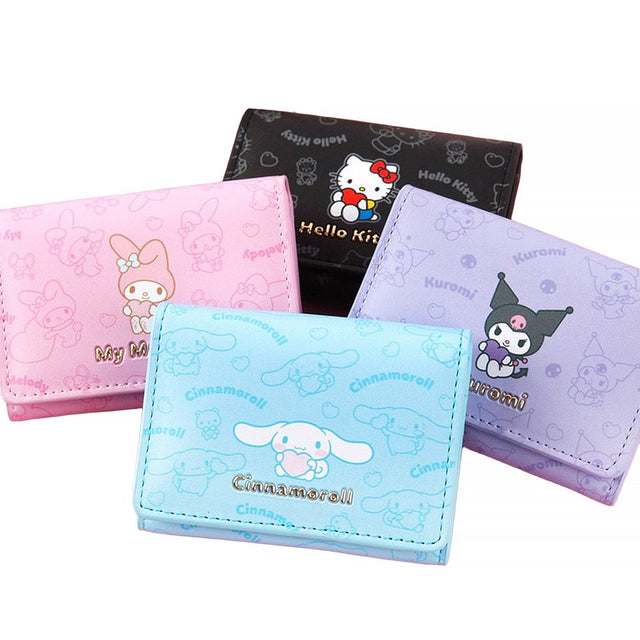 An officially licensed collection of four Sanrio character mini wallets in black, pink, purple, and blue featuring Hello Kitty, My Melody, Cinnamoroll, and Kuromi with gold-lettered names.