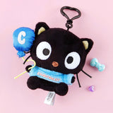 Sanrio Black Chococat plush toy keychain with blue shirts on a pink background