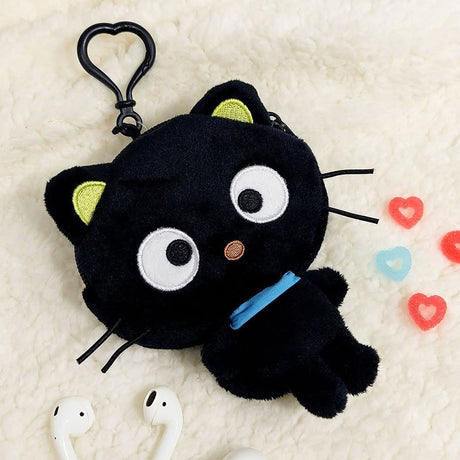 A soft Sanrio Chococat plush flat pouch with a clip-on feature designed to look like a black cat with a blue collar, surrounded by colorful heart-shaped items and white earbuds.