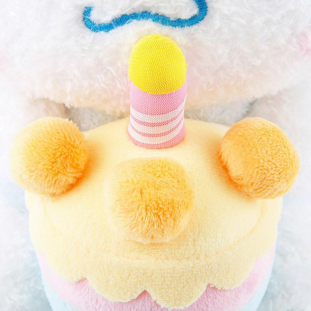 Officially licensed Sanrio Cinnamoroll plush, wearing a charming white party hat topped with a bright yellow tassel, and holding a cake for celebrating a special day.