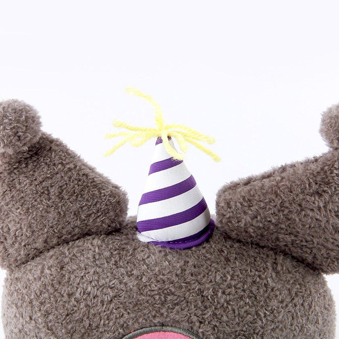 Officially licensed Sanrio Cinnamoroll plush, wearing a charming white party hat topped with a bright yellow tassel, and holding a cake for celebrating a special day.