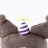 Officially licensed Sanrio Cinnamoroll plush, wearing a charming white party hat topped with a bright yellow tassel, and holding a cake for celebrating a special day.