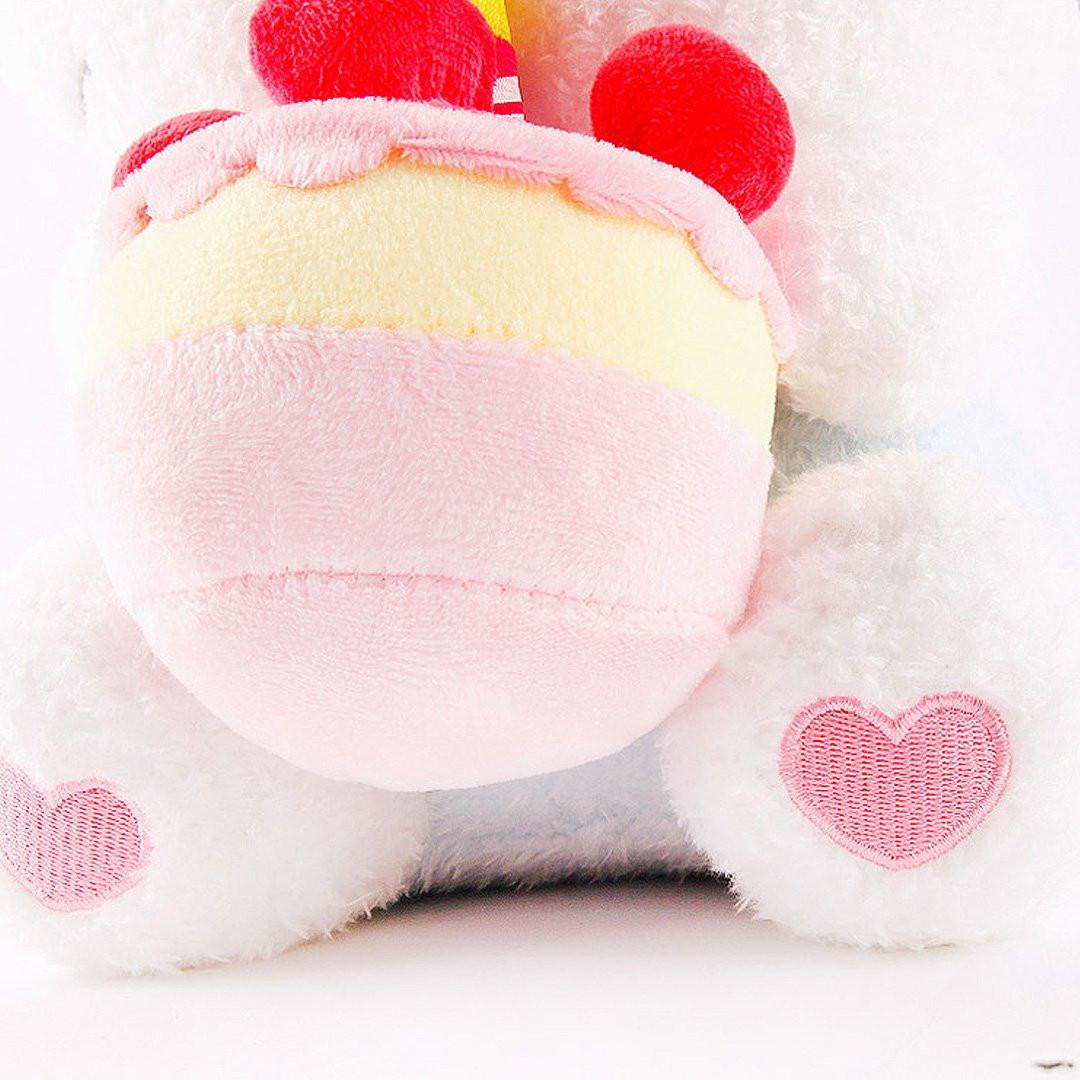 Officially licensed Sanrio Cinnamoroll plush, wearing a charming white party hat topped with a bright yellow tassel, and holding a cake for celebrating a special day.
