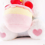 Officially licensed Sanrio Cinnamoroll plush, wearing a charming white party hat topped with a bright yellow tassel, and holding a cake for celebrating a special day.