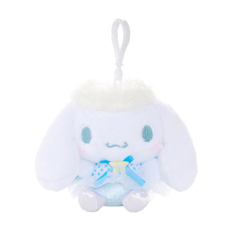 An officially licensed Sanrio Cinnamoroll plush keychain featuring the character in a blue ballerina tutu and polka-dot bodice with a yellow star detail. The plush includes fluffy white head trim, angel wings, and a white plastic clip for easy attachment.
