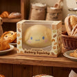 An officially licensed Sanrio Bakery Squishy of Cinnamoroll, shaped like a golden bread bun with blue eyes and pink cheeks