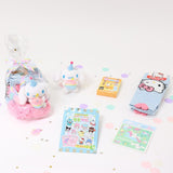 A collection of Sanrio Cinnamoroll Happy Birthday themed gift sets, each containing various colorful items such as plush keychains and socks, all packaged in clear gift bags with pink ribbons.