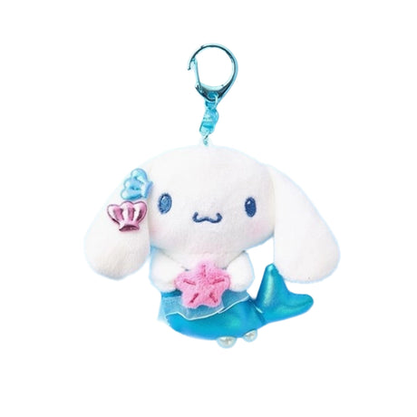 An officially licensed Sanrio character, Cinnamoroll features a shimmering metallic blue mermaid tail that replaces his traditional pup silhouette. The character is holding a pink starfish and has blue and pink shell accessories on its ear.
