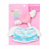 A Sanrio Pitatto Friends M-size doll outfit called the "Angel Set" on a pink polka-dot backing card. The set includes a light blue satin dress with cloud and rainbow prints, white ruffles, and blue bows. Above the dress is a pink plush heart with white wings on a stick. Large white plush wings are shown behind the dress.