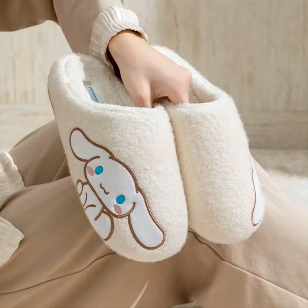A pair of cream white textured sherpa fleece Cinnamoroll slippers with a matching white fleece interior, featuring a side-profile Cinnamoroll embroidery with rosy pink cheeks.