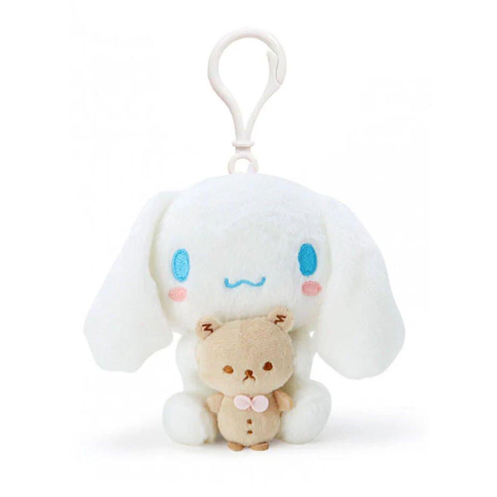 Official Sanrio Cinnamoroll with Kuma-san Mascot Plush Keychain in pure white with signature blue eyes and pink cheeks. This soft-textured white puppy is hugging a small tan bear (Kuma-san), featuring a durable white clip for backpacks. A perfect aesthetic gift for Sanrio fans and kidult collectors seeking soft-core desk accessories and nostalgic healing