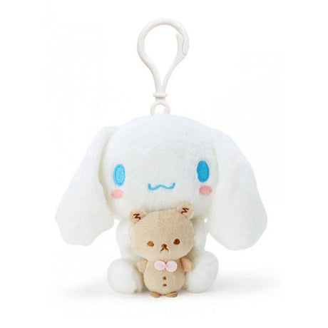 Official Sanrio Cinnamoroll with Kuma-san Mascot Plush Keychain in pure white with signature blue eyes and pink cheeks. This soft-textured white puppy is hugging a small tan bear (Kuma-san), featuring a durable white clip for backpacks. A perfect aesthetic gift for Sanrio fans and kidult collectors seeking soft-core desk accessories and nostalgic healing