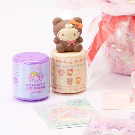 An officially licensed Class of 2026 Sanrio graduation gift set featuring six popular plush characters, Hello Kitty, My Melody, Cinnamoroll, Kuromi, Pompompurin, and Pochacco wearing black graduation caps. The characters are arranged like a bouquet with silver star balloons and "Congrats Grad" decorations.