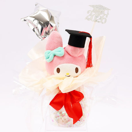 An officially licensed Class of 2026 Sanrio graduation gift set featuring six popular plush characters, Hello Kitty, My Melody, Cinnamoroll, Kuromi, Pompompurin, and Pochacco wearing black graduation caps. The characters are arranged like a bouquet with silver star balloons and "Congrats Grad" decorations.
