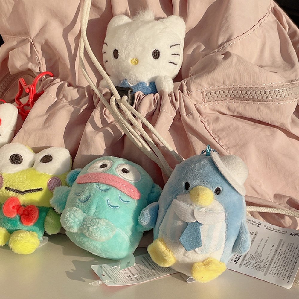 Sanrio, Keroppi, Hangyodon, Tuxedosam, Dear Daniel plush toys in front of a pink backpack. Ideal as collectible bag charms and accessories.