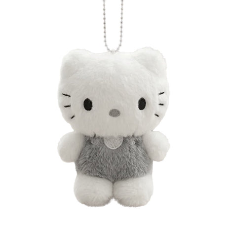 A fluffy white Dear Daniel plush doll keychain wearing textured grey overalls with a heart patch