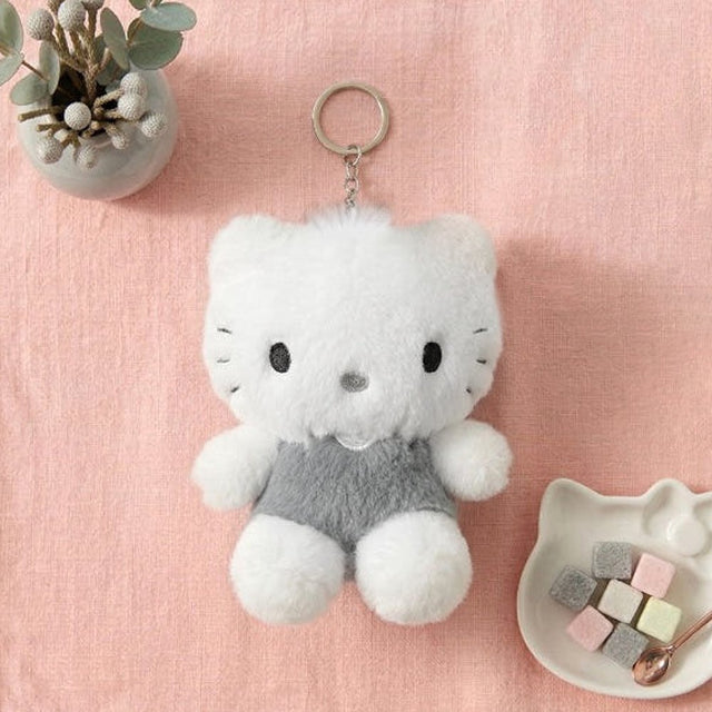 An officially licensed Sanrio Dear Daniel fluffy white plush keychain wearing a gray romper outfit
