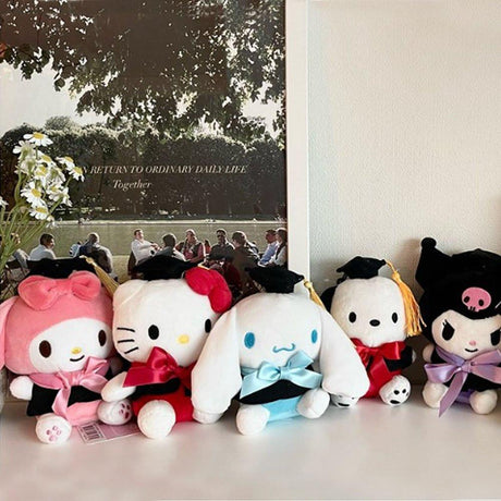An officially licensed Sanrio Hello Kitty, My Melody, Cinnamoroll, Kuromi, and Pochacco plush toys dressed in a black graduation cap with a gold tassel and a matching gown featuring a large red bow