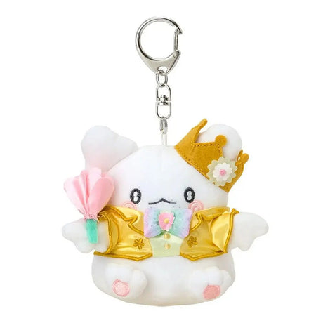A plush keychain of the Sanrio character Hanamaruobake, a white bear with pink blush on his cheeks. He is wearing a golden crown with a white flower, a shiny yellow tuxedo jacket with gold trim, and a pastel rainbow bowtie. He holds a soft pink flower in his hand and is attached to a silver metal lobster clasp.