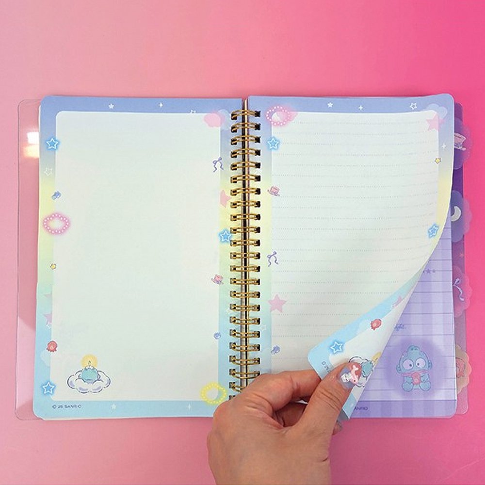 An officially licensed Sanrio Hangyodon spiral-bound notebook, featuring a glitter finish with gold stars and an illustration of Hangyodon. Includes four distinct, colorful dividers and five different interior page designs.