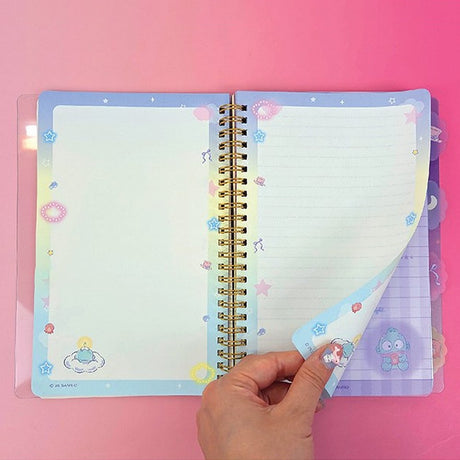 An officially licensed Sanrio Hangyodon spiral-bound notebook, featuring a glitter finish with gold stars and an illustration of Hangyodon. Includes four distinct, colorful dividers and five different interior page designs.