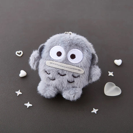 An officially licensed Sanrio character, this fluffy Hangyodon plush keychain features his signature large, wide-set eyes—rendered in crisp monochromatic schemed embroidery—and his iconic flat, grey-toned lips.