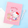 A soft pink, officially licensed Hello Kitty spiral lined notebook featuring Hello Kitty having a tea party with her teddy bear.