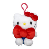 Officially licensed Hello Kitty plush keychain sitting and holding a large red plush bow, featuring her classic white fur, yellow nose, and signature red ear bow.
