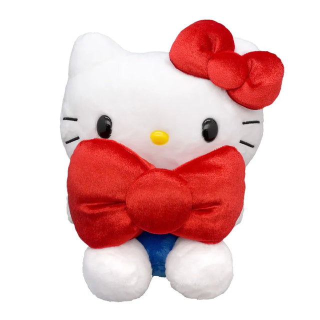Officially licensed Hello Kitty plush toy sitting and holding a large red plush bow, featuring her classic white fur, yellow nose, and signature red ear bow.