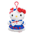 Officially licensed Hello Kitty plush keychain wearing a detailed white and blue dress with a scalloped white collar, red buttons, an apple-printed blue skirt, and a white eyelet lace hem, with a mini Hello Kitty face crossbody bag.